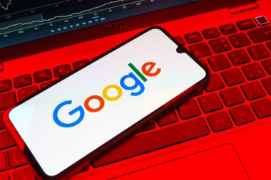 Prag, Çek Cumhuriyeti - 08 18 2025: Klavyede bir cep telefonu Google logosunu görüntüler. Google bilgi için bir arama motoru ve teknoloji platformudur.