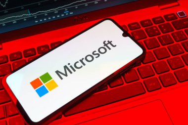 Prag, Çek Cumhuriyeti - 08 18 2025: Klavyede bir cep telefonu Microsoft logosu sergiler. Microsoft yazılım, donanım ve hizmet sunan bir teknoloji şirketidir..