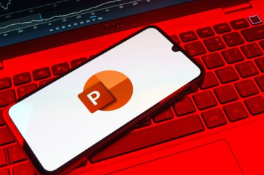 Prag, Çek Cumhuriyeti - 08 18 2025: Klavyede bir cep telefonu Powerpoint logosu sergiler. Powerpoint sunumlar ve slayt gösterileri oluşturmak için bir yazılımdır..
