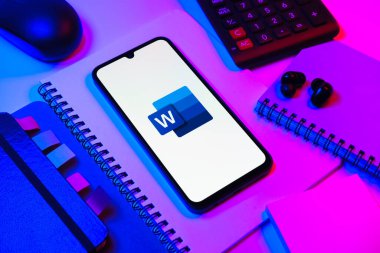 Prag, Çek Cumhuriyeti - 08 18 2025: Merkezinde Word logosu sergilenen bir cep telefonu ile ofis malzemeleri düzenlemesi. Word belge yaratmak ve düzenlemek için bir yazılımdır..