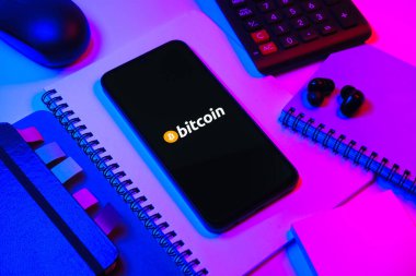 Prag, Çek Cumhuriyeti - 08 18 2025: Merkezde Bitcoin logosu sergilenen bir cep telefonu ile ofis malzemeleri düzenlemesi. Bitcoin merkezi olmayan işlemler için dijital bir kripto para birimidir.