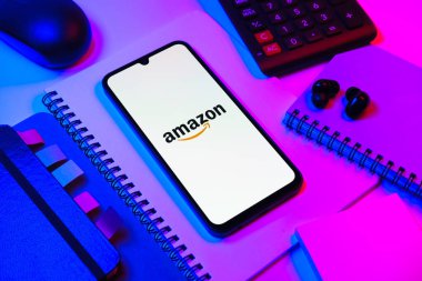 Prag, Çek Cumhuriyeti - 08 18 2025: Merkezinde Amazon logosu sergilenen bir cep telefonu ile ofis malzemeleri düzenlemesi. Amazon, alışveriş ürünleri ve hizmetleri için çevrimiçi bir platformdur..
