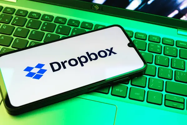 Prag, Çek Cumhuriyeti - 08 01 2025: Laptop klavyesinde duran bir cep telefonu Dropbox logosunu gösterir. Dropbox bulut depolama ve dosya paylaşımı için bir platformdur.