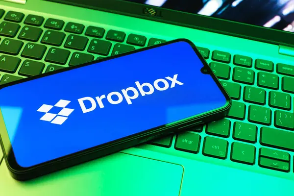 Prag, Çek Cumhuriyeti - 08 01 2025: Laptop klavyesinde duran bir cep telefonu Dropbox logosunu gösterir. Dropbox bulut depolama ve dosya paylaşımı için bir platformdur.