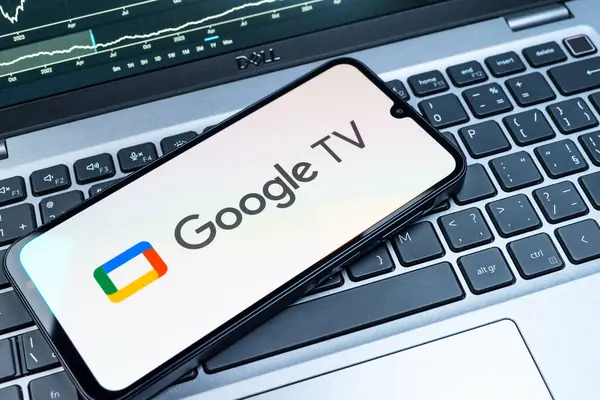 Prag, Çek Cumhuriyeti - 08 18 2025: Bir klavyede bir cep telefonu Google TV logosu görüntüler. Google TV film, program ve uygulamalar için bir platformdur..