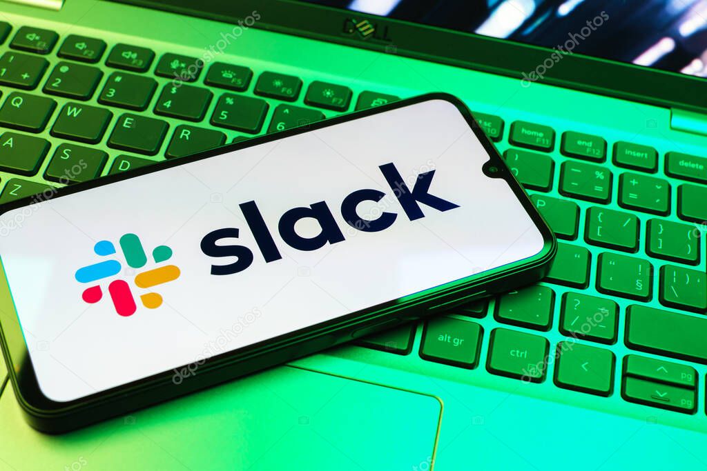 Prague, Czechia - 08 01 2025: A mobile phone lying on a laptop keyboard displays the Slack logo. Slack is a platform for team messaging and workplace communication.