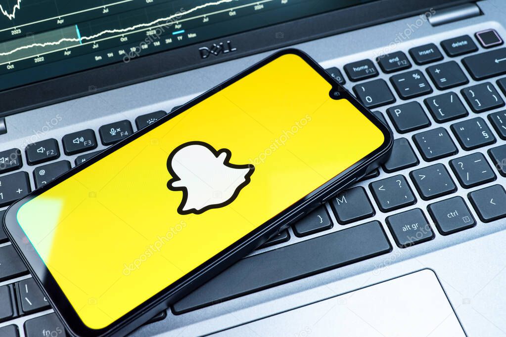 Prague, Czechia - 08 18 2025: A mobile phone on a keyboard displays Snapchat logo. Snapchat is an app for sending photos, videos, and temporary messages.