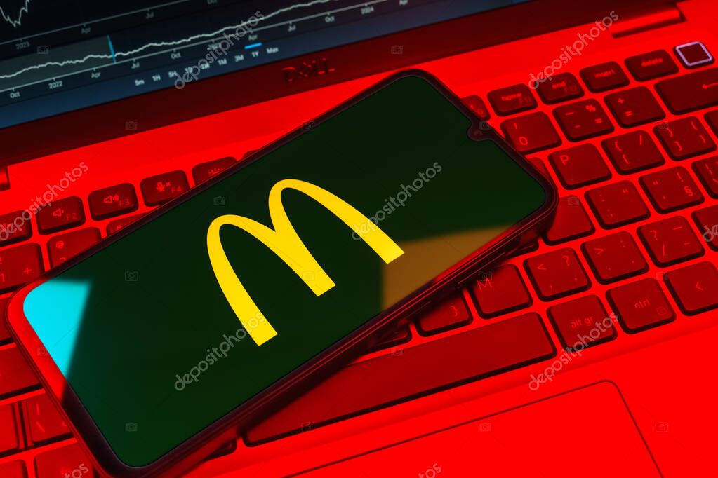 Prague, Czechia - 08 18 2025: A mobile phone on a keyboard displays McDonalds logo. McDonalds is a fast-food chain serving burgers, fries, and more.