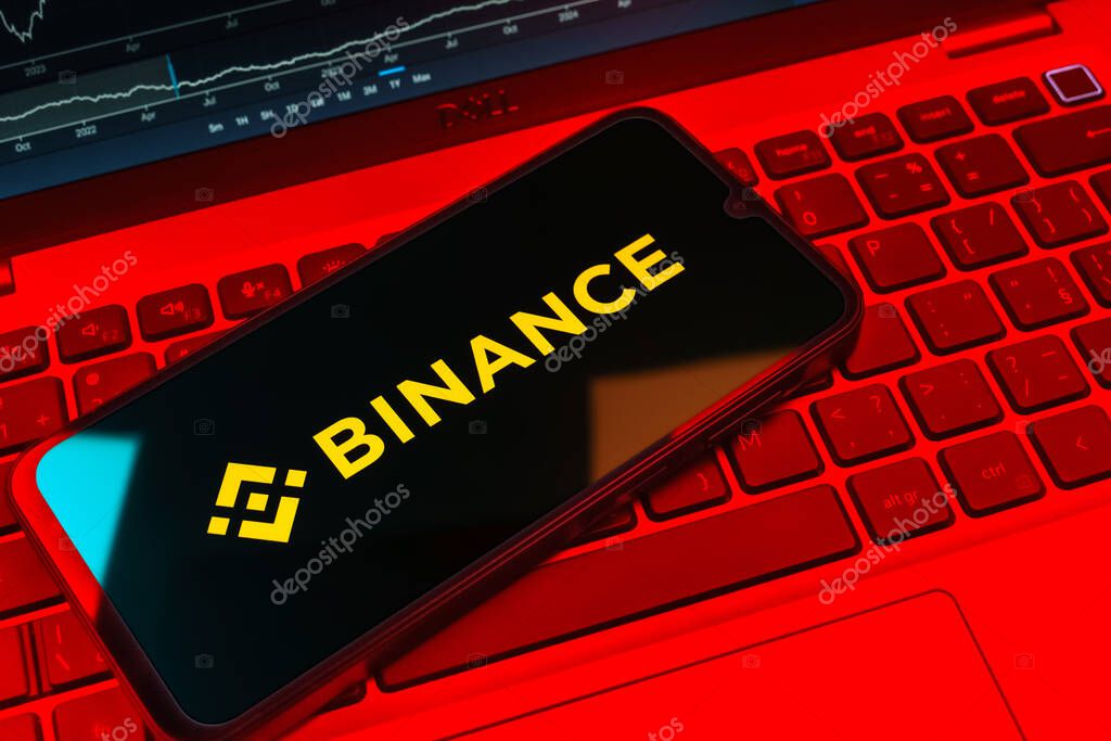 Prague, Czechia - 08 18 2025: A mobile phone on a keyboard displays Binance logo. Binance is a cryptocurrency exchange for trading digital assets.