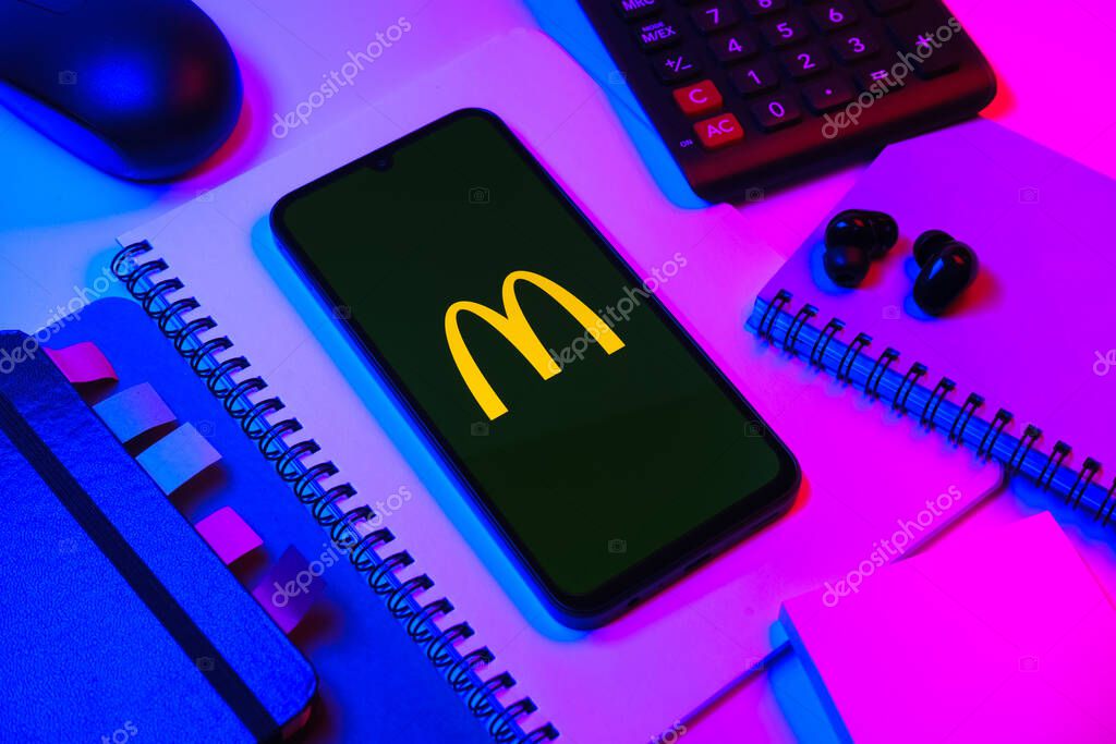 Prague, Czechia - 08 18 2025: An arrangement of office supplies with a mobile phone in the center displaying McDonalds logo. McDonalds is a fast-food chain serving burgers, fries, and more.