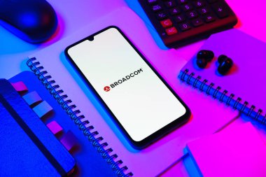 Prag, Çek Cumhuriyeti - 08 18 2025: Merkezde Broadcom logosunu gösteren bir cep telefonu ile ofis malzemeleri düzenlemesi. Broadcom, çip ve ağ donanımı üreten yarı iletken bir şirket..