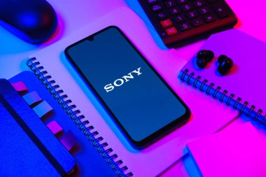 Prag, Çek Cumhuriyeti - 08 18 2025: Merkezde Sony logosunu gösteren bir cep telefonu ile ofis malzemeleri düzenlemesi. Sony elektronik, oyun ve eğlence üreten bir teknoloji şirketidir..