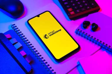 Prag, Çek Cumhuriyeti - 08 18 2025: Posta şempanzesinin logosunu gösteren bir cep telefonu ile ofis malzemeleri düzenlemesi. Posta şempanzesi e-posta pazarlama ve otomasyon için bir platformdur.