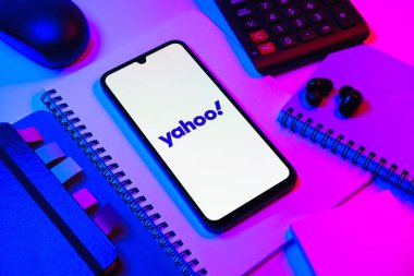 Prag, Çek Cumhuriyeti - 08 18 2025: Merkezde Yahoo logosunu gösteren bir cep telefonu ile ofis malzemeleri düzenlemesi. Yahoo haber, e-posta ve internet hizmetleri için bir platformdur..