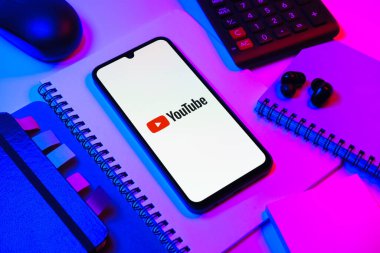 Prag, Çek Cumhuriyeti - 08 18 2025: Merkezde Youtube logosu sergilenen bir cep telefonu ile ofis malzemeleri düzenlemesi. Youtube dünya çapında videoları izlemek ve paylaşmak için bir platform.