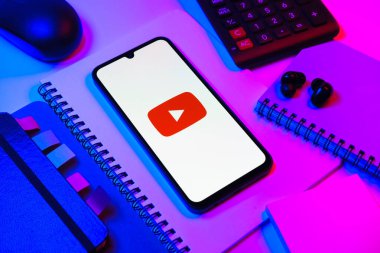 Prag, Çek Cumhuriyeti - 08 18 2025: Merkezde Youtube logosu sergilenen bir cep telefonu ile ofis malzemeleri düzenlemesi. Youtube dünya çapında videoları izlemek ve paylaşmak için bir platform.