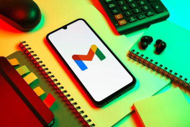 Prag, Çek Cumhuriyeti - 08 18 2025: Merkezde Google Gmail logosunu gösteren bir cep telefonu ile ofis malzemeleri düzenlemesi. Google Gmail, mesaj göndermek ve almak için kullanılan bir e-posta servisidir..