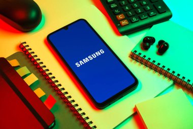 Prag, Çek Cumhuriyeti - 08 18 2025: Merkezde Samsung logosu sergilenen bir cep telefonu ile ofis malzemeleri düzenlemesi. Samsung elektronik ve cihaz üreten bir teknoloji şirketi..