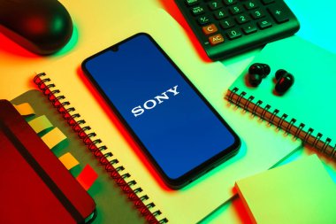 Prag, Çek Cumhuriyeti - 08 18 2025: Merkezde Sony logosunu gösteren bir cep telefonu ile ofis malzemeleri düzenlemesi. Sony elektronik, oyun ve eğlence üreten bir teknoloji şirketidir..