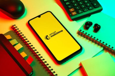 Prag, Çek Cumhuriyeti - 08 18 2025: Posta şempanzesinin logosunu gösteren bir cep telefonu ile ofis malzemeleri düzenlemesi. Posta şempanzesi e-posta pazarlama ve otomasyon için bir platformdur.