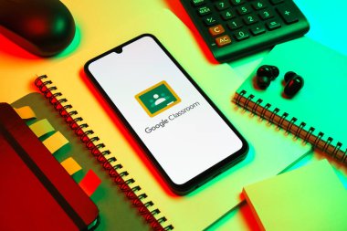 Prag, Çek Cumhuriyeti - 08 18 2025: Merkezde Google Sınıfı logosunu gösteren bir cep telefonu ile ofis malzemeleri düzenlemesi. Google Sınıfı, sınıfları ve eğitim içeriğini yönetmek için bir platformdur.