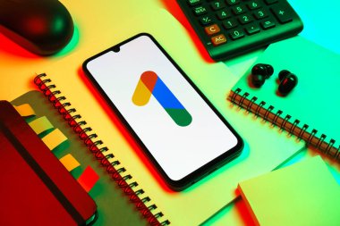 Prag, Çek Cumhuriyeti - 08 18 2025: Merkezinde Google One logosu bulunan bir cep telefonu ile ofis malzemeleri düzenlemesi. Google 1 bulut depolama ve abonelik hizmetleri için bir platformdur.
