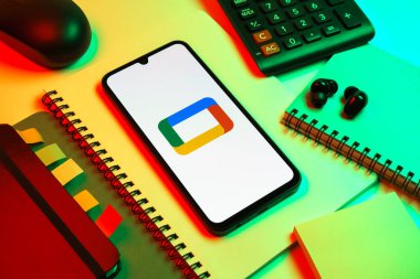Prag, Çek Cumhuriyeti - 08 18 2025: Merkezde Google TV logosunu gösteren bir cep telefonu ile ofis malzemeleri düzenlemesi. Google TV film, program ve uygulamalar için bir platformdur..