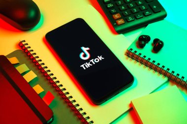 Prag, Çek Cumhuriyeti - 08 18 2025: Merkezde TikTok logosunu gösteren bir cep telefonu ile ofis malzemeleri düzenlemesi. TikTok kısa, yaratıcı ve viral video platformu.