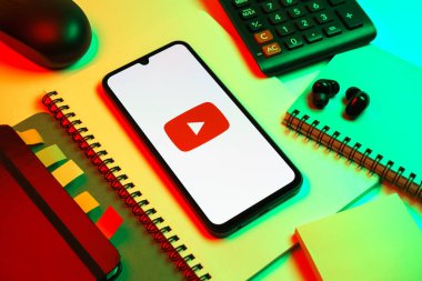 Prag, Çek Cumhuriyeti - 08 18 2025: Merkezde Youtube logosu sergilenen bir cep telefonu ile ofis malzemeleri düzenlemesi. Youtube dünya çapında videoları izlemek ve paylaşmak için bir platform.