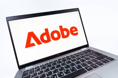 Prag, Çek Cumhuriyeti - 08 12 2025: Adobe logosunu gösteren bir dizüstü bilgisayarın dinamik yakın çekimi. Adobe yaratıcı araçlar ve hizmetler sunan bir yazılım şirketidir..