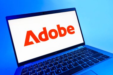 Prag, Çek Cumhuriyeti - 08 12 2025: Adobe logosunu gösteren bir dizüstü bilgisayarın dinamik yakın çekimi. Adobe yaratıcı araçlar ve hizmetler sunan bir yazılım şirketidir..