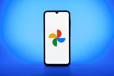 Prag, Çek Cumhuriyeti - 08 10 2025: Tek tip arka planda duran bir cep telefonu Google Photos logosunu görüntüler. Google Fotoğrafları fotoğraf ve videoları saklamak ve düzenlemek için bir platformdur.
