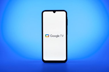 Prag, Çek Cumhuriyeti - 08 10 2025: Tek kullanımlık arka planda duran bir cep telefonu Google TV logosunu gösteriyor. Google TV film, program ve uygulamalar için bir platformdur..
