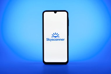 Prag, Çek Cumhuriyeti - 08 10 2025: Tek kullanımlık arka planda duran bir cep telefonu Skyscanner logosunu gösteriyor. Skyscanner uçak, otel ve araba kiralama araçlarını karşılaştırmak için bir platform..