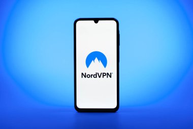 Prag, Çek Cumhuriyeti - 08 10 2025: Arka planda duran bir cep telefonu NordVPN logosunu gösteriyor. NordVPN güvenli ve özel internet taraması için bir platformdur.