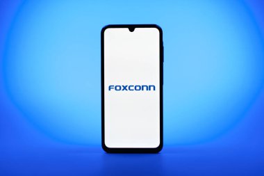 Prag, Çek Cumhuriyeti - 08 10 2025: Tek kullanımlık arka planda duran bir cep telefonu Foxconn logosunu gösteriyor. Foxconn elektronik ve parça üreten bir şirket..