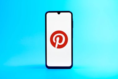 Prag, Çek Cumhuriyeti - 08 10 2025: Tek kullanımlık arka planda duran bir cep telefonu Pinterest logosunu gösteriyor. Pinterest fikirleri görsel olarak keşfetmek ve kaydetmek için bir platformdur..
