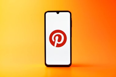 Prag, Çek Cumhuriyeti - 08 10 2025: Tek kullanımlık arka planda duran bir cep telefonu Pinterest logosunu gösteriyor. Pinterest fikirleri görsel olarak keşfetmek ve kaydetmek için bir platformdur..