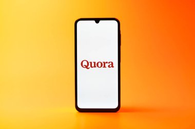 Prag, Çek Cumhuriyeti - 08 10 2025: Uniforma arka planda duran bir cep telefonu Quora logosunu gösteriyor. Quora soru sormak ve bilgi paylaşmak için bir platformdur..