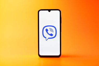Prag, Çek Cumhuriyeti - 08 10 2025: Arka planda duran bir cep telefonu Viber logosunu gösteriyor. Viber aramalar, mesajlar ve medya paylaşımı için bir mesajlaşma uygulamasıdır.
