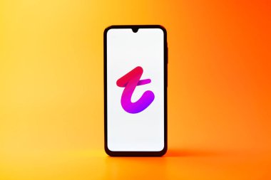 Prag, Çek Cumhuriyeti - 08 10 2025: Tek kullanımlık arka planda duran bir cep telefonu Tango logosunu gösteriyor. Tango, görüntülü aramalar, mesajlar ve canlı yayınlar için sosyal bir uygulama..