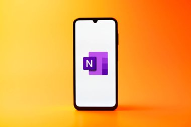 Prag, Çek Cumhuriyeti - 08 10 2025: Tek kullanımlık arka planda duran bir cep telefonu Microsoft OneNote logosunu gösteriyor. Microsoft OneNote not almak ve düzenlemek için bir platformdur.