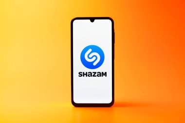 Prag, Çek Cumhuriyeti - 08 10 2025: Arka planda duran bir cep telefonu Shazam logosunu gösteriyor. Shazam şarkıları ve müzik parçalarını tanımlamak için bir uygulamadır.