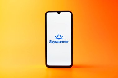 Prag, Çek Cumhuriyeti - 08 10 2025: Tek kullanımlık arka planda duran bir cep telefonu Skyscanner logosunu gösteriyor. Skyscanner uçak, otel ve araba kiralama araçlarını karşılaştırmak için bir platform..