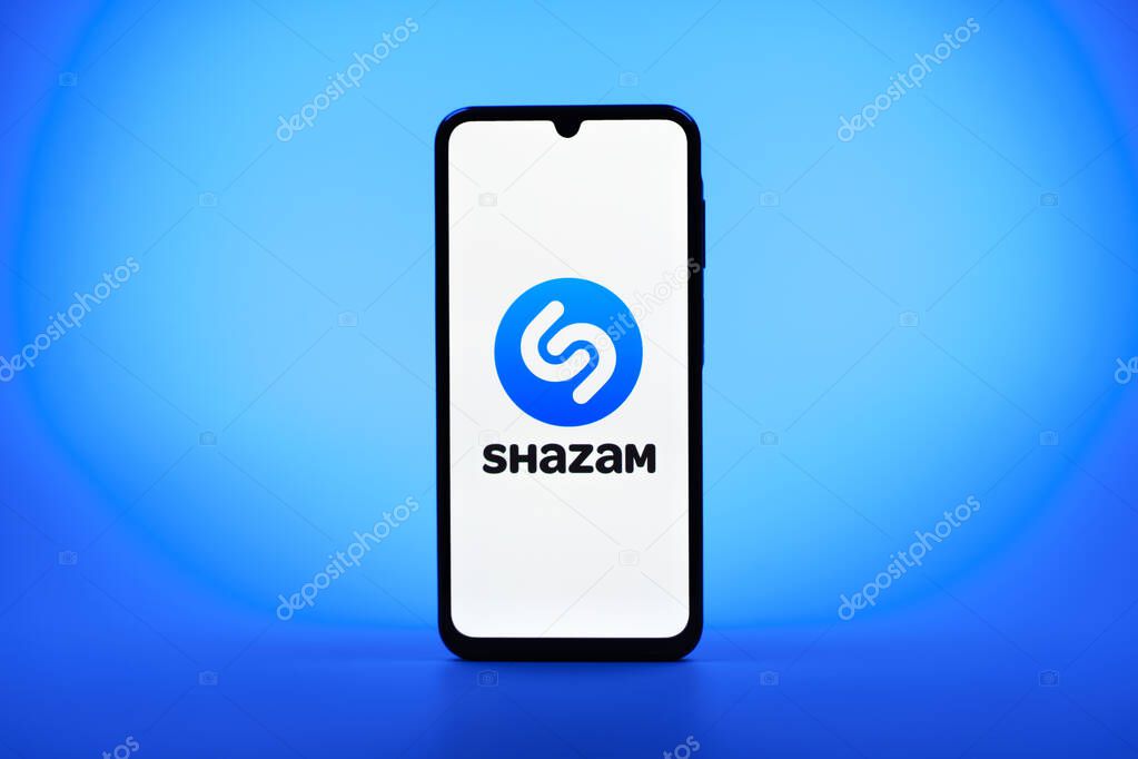 Prague, Czechia - 08 10 2025: A mobile phone standing on a uniform background displays the Shazam logo. Shazam is an app for identifying songs and music tracks.