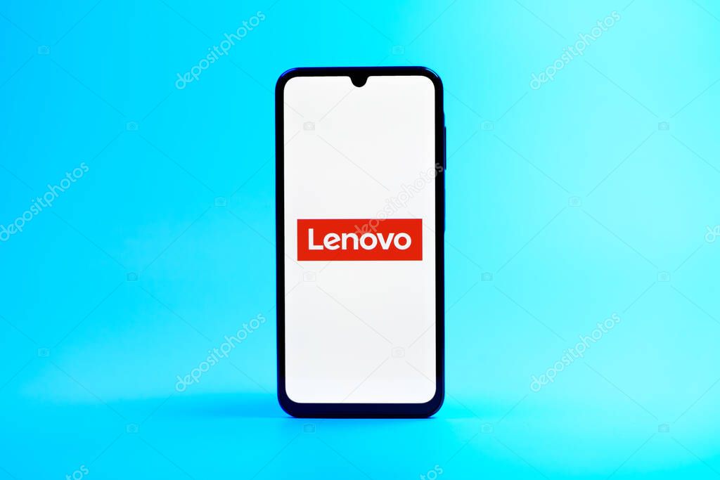 Prague, Czechia - 08 10 2025: A mobile phone standing on a uniform background displays the Lenovo logo. Lenovo is a technology company producing computers and electronics.