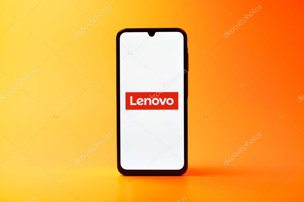 Prague, Czechia - 08 10 2025: A mobile phone standing on a uniform background displays the Lenovo logo. Lenovo is a technology company producing computers and electronics.