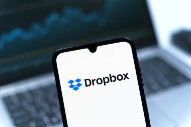 Prag, Çek Cumhuriyeti - 08 12 2025: Bilgisayarın önünde duran bir cep telefonu Dropbox logosunu gösteriyor. Dropbox bulut depolama ve dosya paylaşımı için bir platformdur.