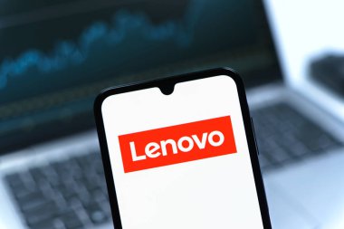 Prag, Çek Cumhuriyeti - 08 12 2025: Bilgisayarın önünde duran bir cep telefonu Lenovo logosunu gösteriyor. Lenovo bilgisayar ve elektronik üreten bir teknoloji şirketidir..