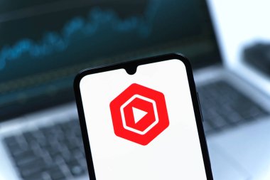 Prag, Çek Cumhuriyeti - 08 12 2025: Bir dizüstü bilgisayarın önünde duran bir cep telefonu Youtube Stüdyo logosunu gösteriyor. Youtube Studio YouTube kanallarını yönetmek ve analiz etmek için bir platformdur.